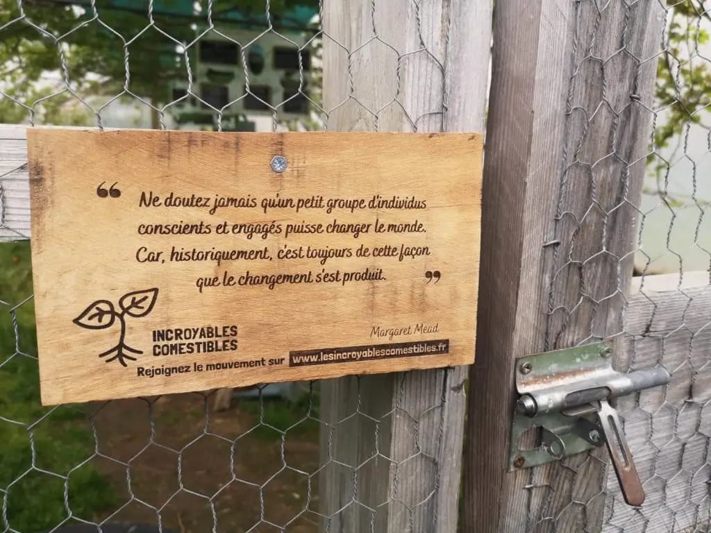 Panneau en bois à l'entrée d'un jardin partagé des Incroyables Comestibles, invitation à l'action